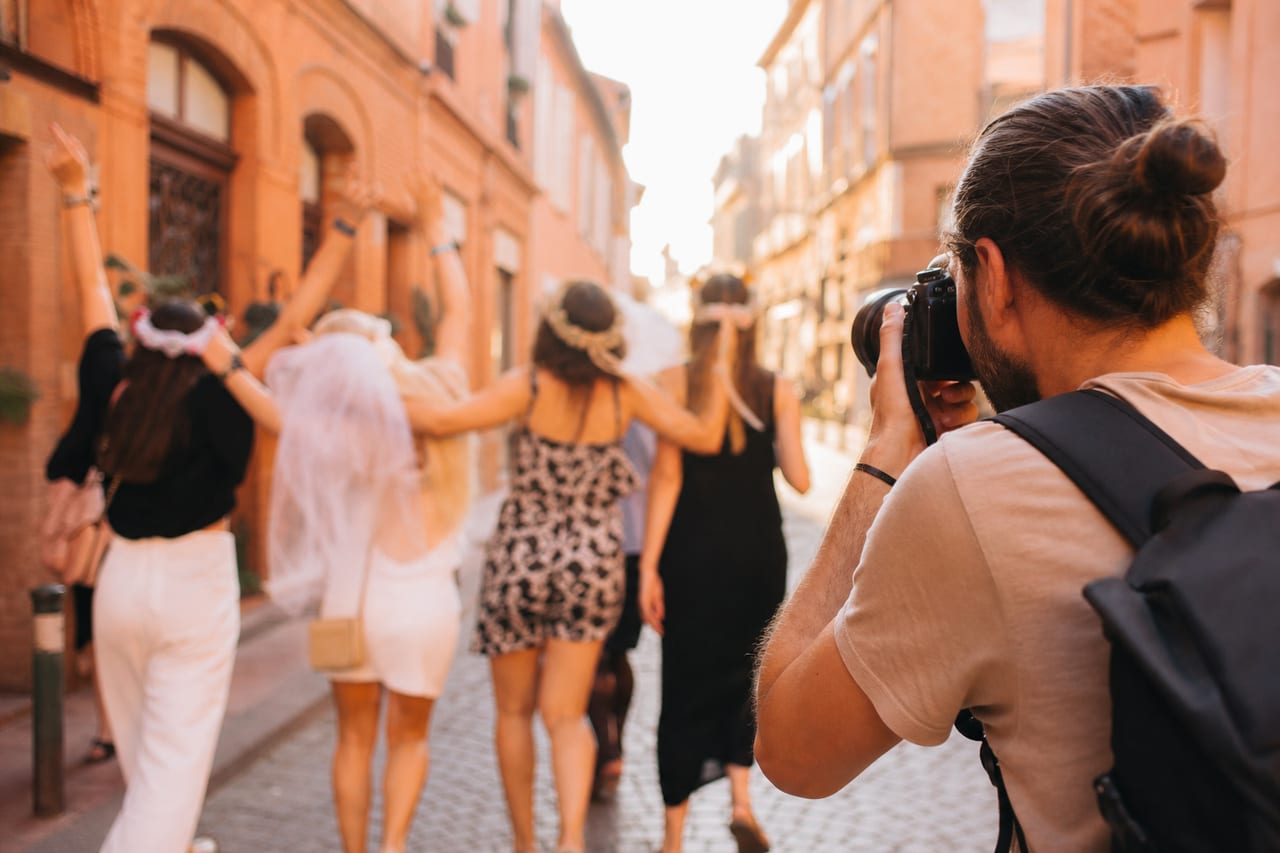 Photographe EVJF à Toulouse : groupe de femmes dans une rue et photographe en action.